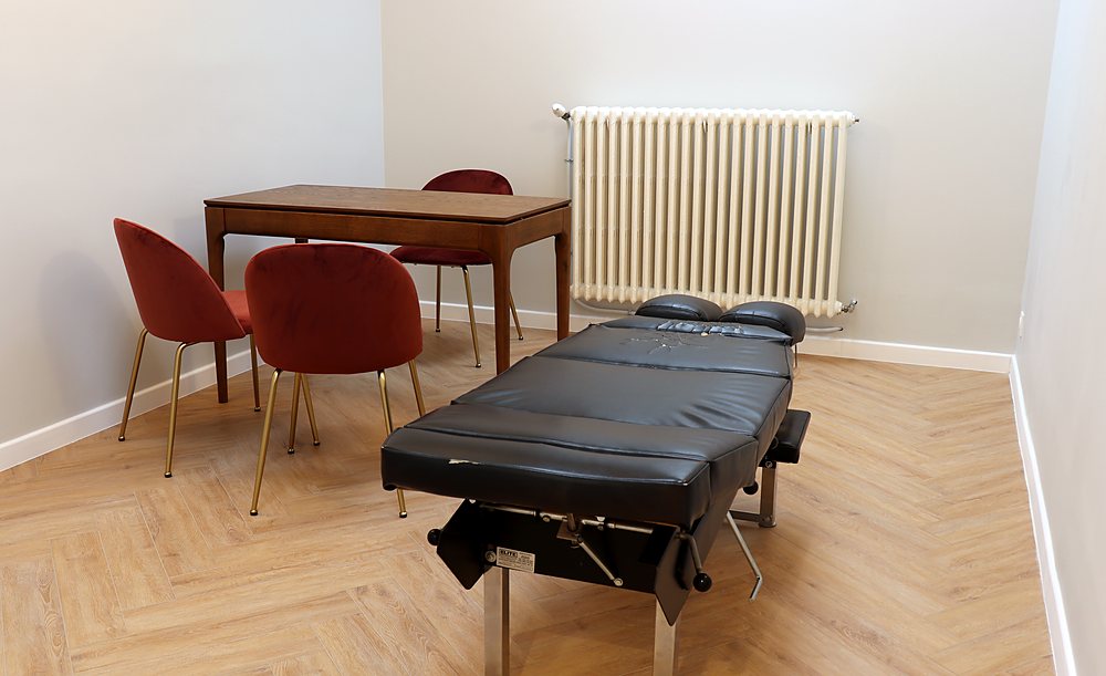 Salle de face vue d'angle, table de chiropraxie à drops et espace bureau